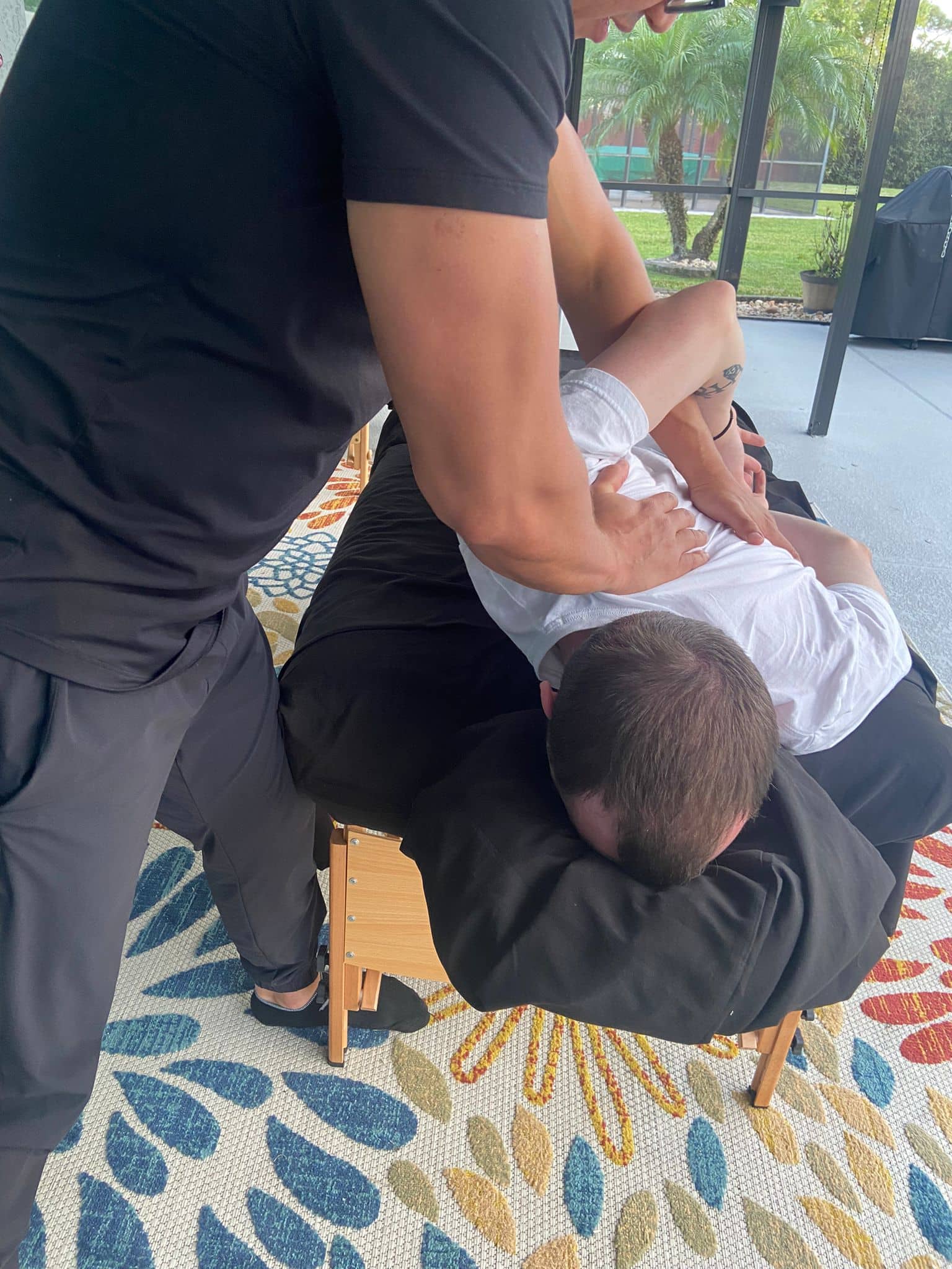 Angel performing sports massage therapy by the pool